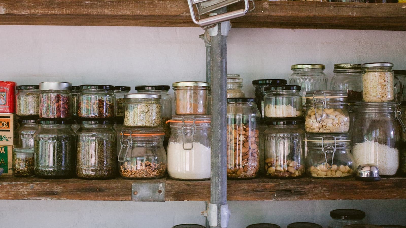 Uporządkowane półki z produktami spożywczymi w szklanych słoikach