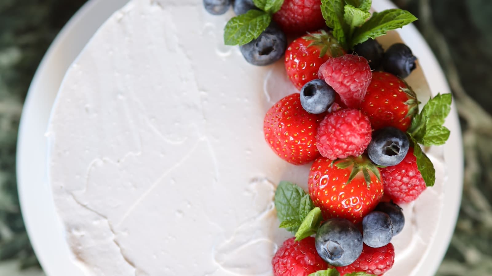 Świeże maliny, truskawki i borówki w miskach na stole