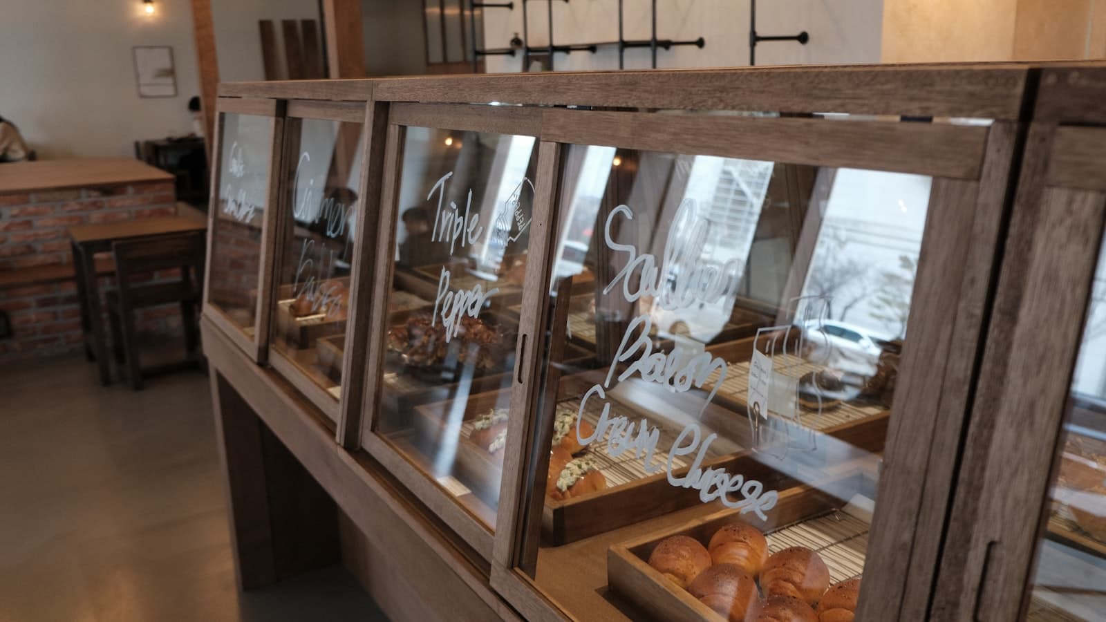 Elegancka witryna cukierni z eklerami, tartami i deserami na półkach